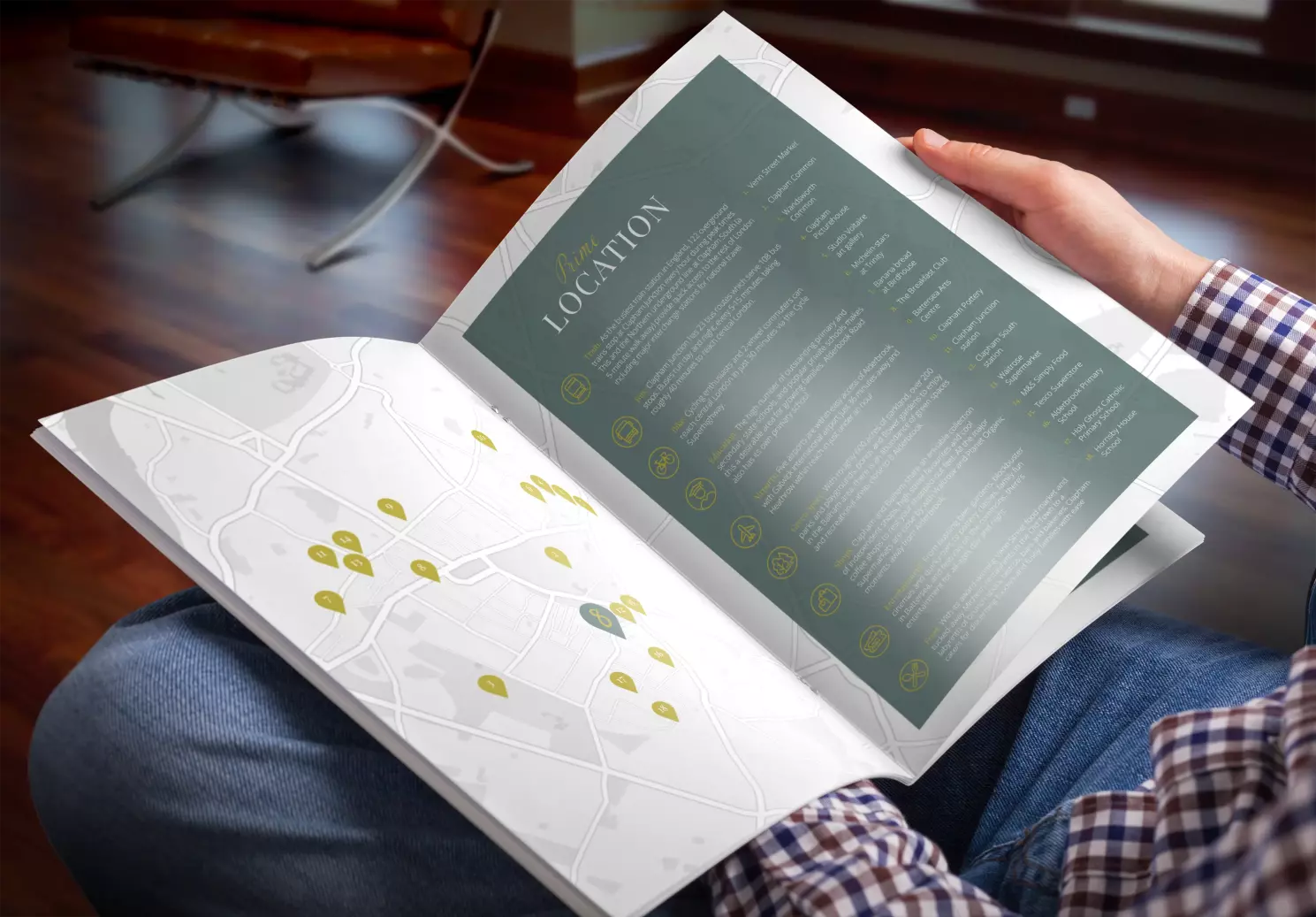 Picture of a man sitting down and holding the Alderbrook Road property brochure open and looking at the map page